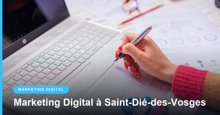 Main avec un stylo analysant des graphiques à côté d’un ordinateur portable