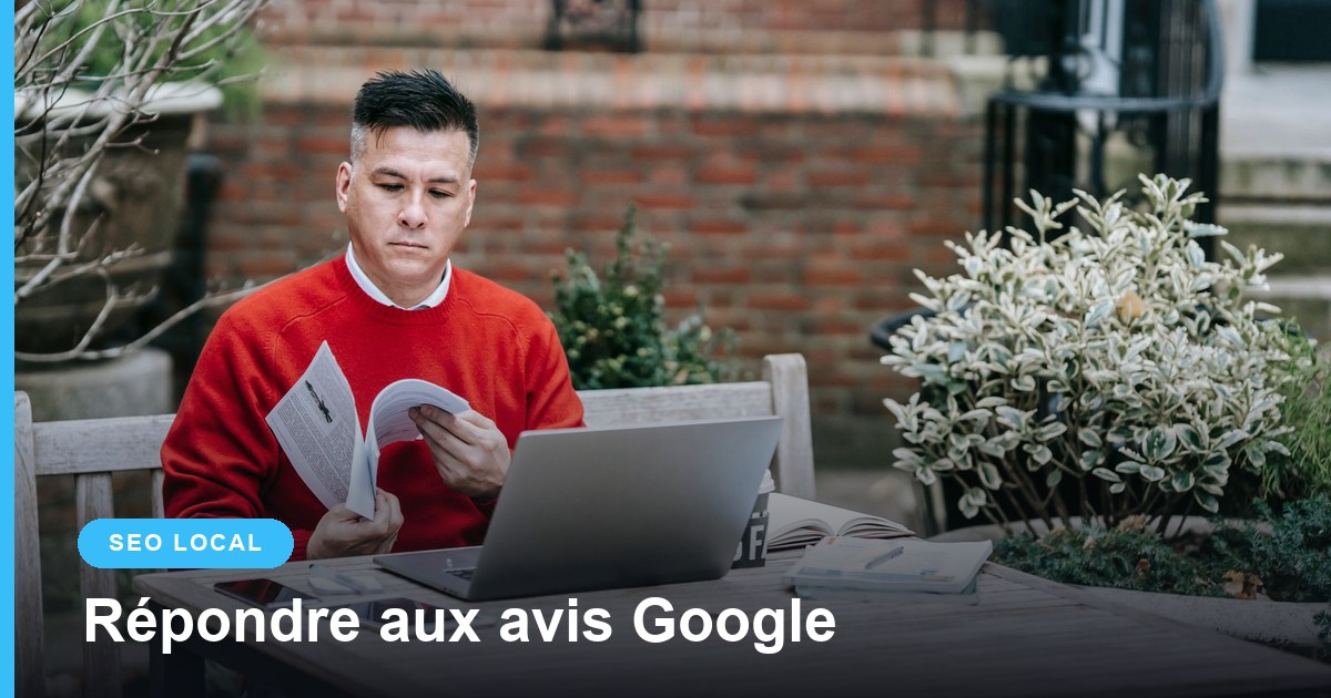Gérant lisant des documents devant son ordinateur portable en terrasse