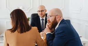 Conseiller recevant deux clients dans un bureau moderne