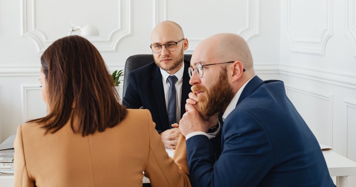 Conseiller recevant deux clients dans un bureau moderne