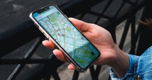 Main tenant un smartphone affichant une carte