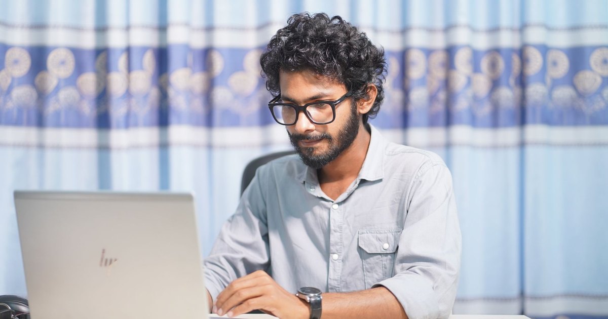 Jeune homme concentré travaillant sur un ordinateur portable
