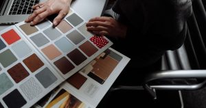 Designer consultant un nuancier de couleurs devant son ordinateur