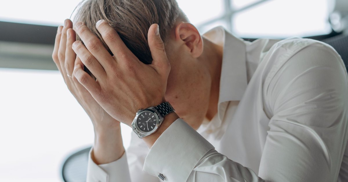 Professionnel stressé se tenant la tête dans les mains