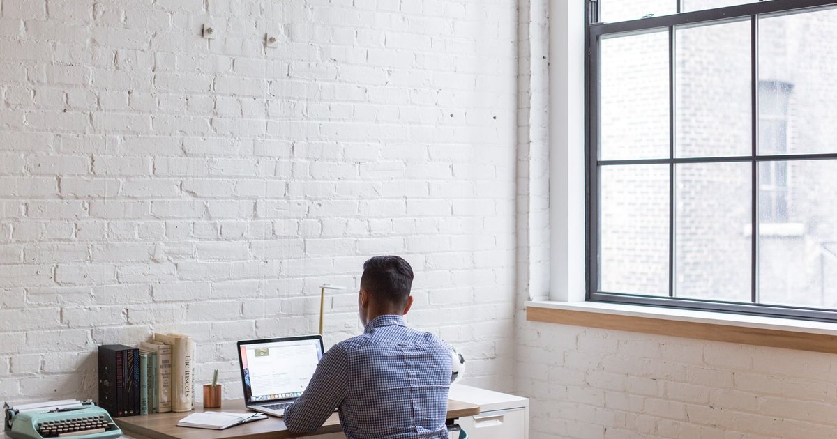 Homme travaillant sur ordinateur portable dans un bureau à domicile lumineux