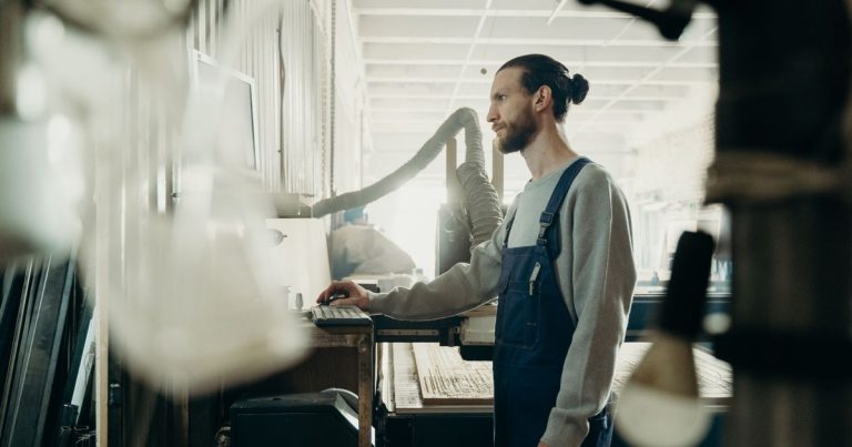Homme en salopette travaillant dans un atelier industriel