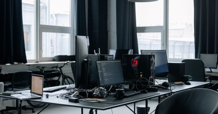 Bureau d'entreprise équipé de plusieurs postes informatiques devant de grandes fenêtres