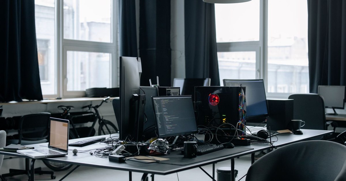 Bureau d'entreprise équipé de plusieurs postes informatiques devant de grandes fenêtres