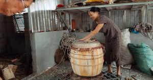 Artisane fabriquant un tambour en bois dans son atelier