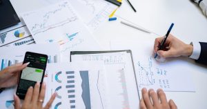 Collègues analysant des graphiques sur papier et sur smartphone