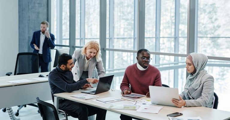 Groupe de professionnels échangeant des idées dans un bureau lumineux