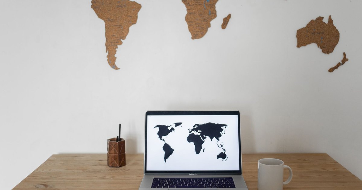 Ordinateur portable affichant une carte du monde sur un bureau