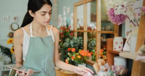 Fleuriste travaillant dans sa boutique entourée de fleurs