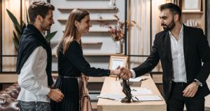 Poignée de main entre un conseiller et un couple lors d'un rendez-vous