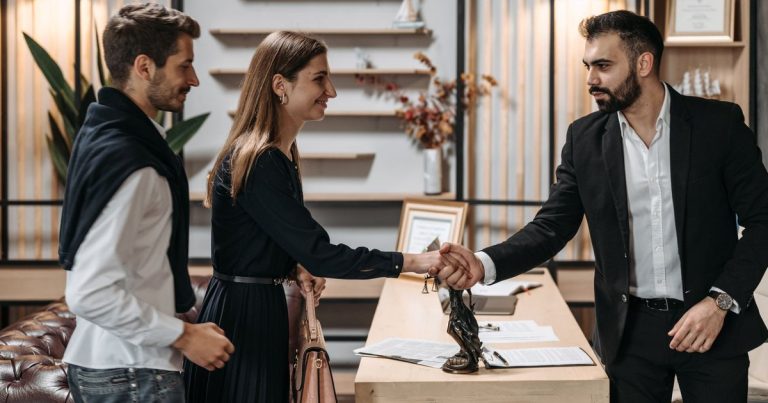 Poignée de main entre un conseiller et un couple lors d'un rendez-vous