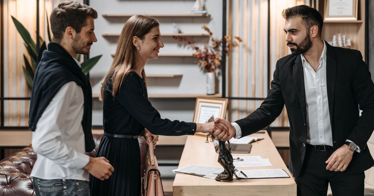 Poignée de main entre un conseiller et un couple lors d'un rendez-vous
