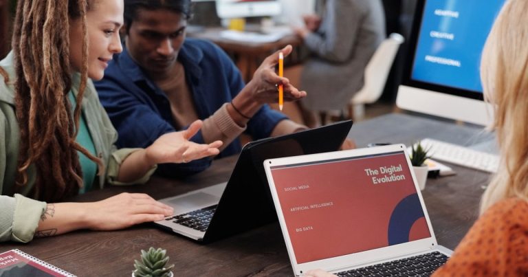 Équipe travaillant ensemble sur ordinateurs portables dans un bureau moderne