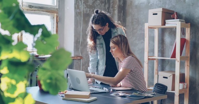 Deux jeunes femmes travaillant ensemble sur un ordinateur portable dans un bureau