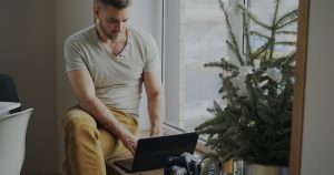 Homme travaillant sur un ordinateur portable près d'une fenêtre
