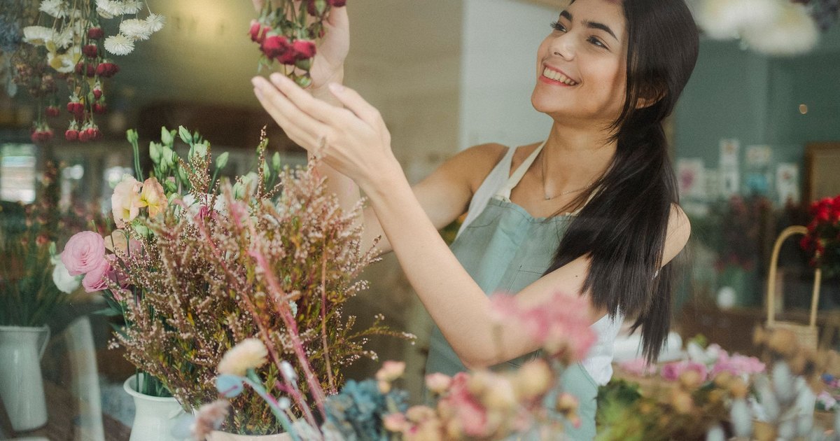 Fleuriste souriante composant des bouquets dans sa boutique