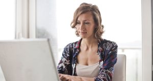 Femme travaillant sur un ordinateur portable dans un bureau lumineux