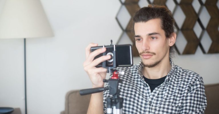 Créateur de contenu se filmant avec un smartphone monté sur trépied