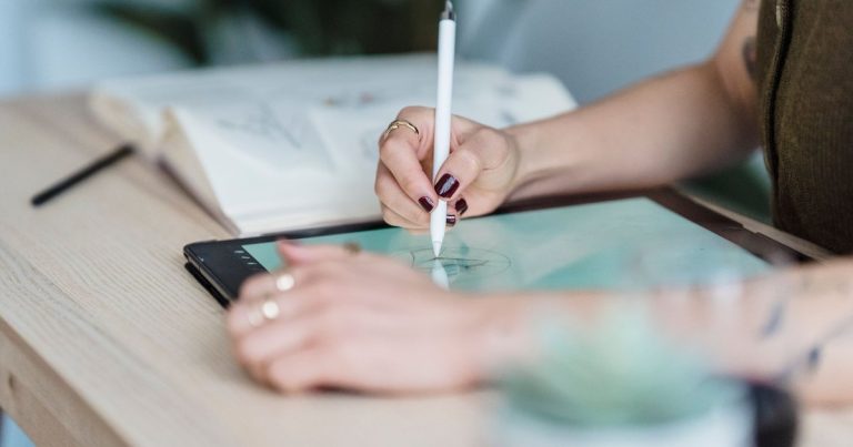 Graphiste dessinant un logo sur une tablette avec un stylet