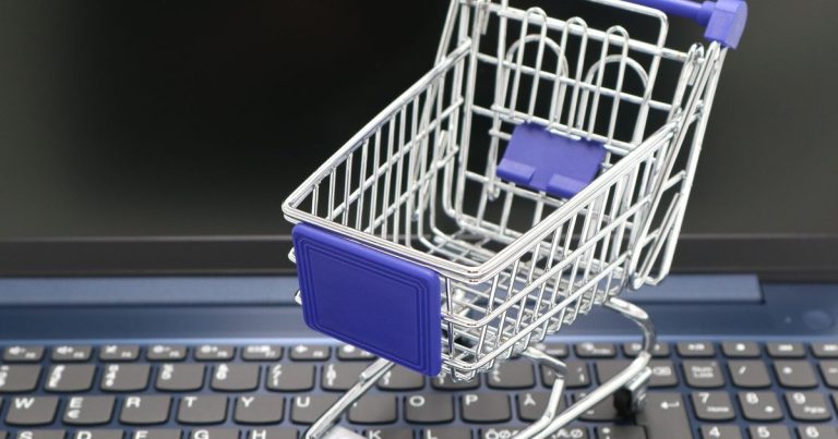 Petit chariot de courses posé sur le clavier d'un ordinateur portable