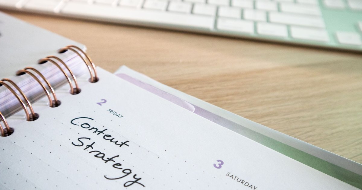 Agenda à spirale avec les mots « Content Strategy » écrits à la main près d’un clavier